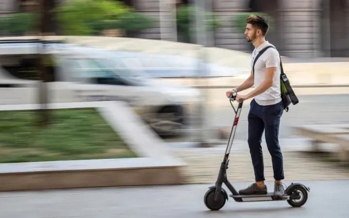 homme se déplaçant en trottinette